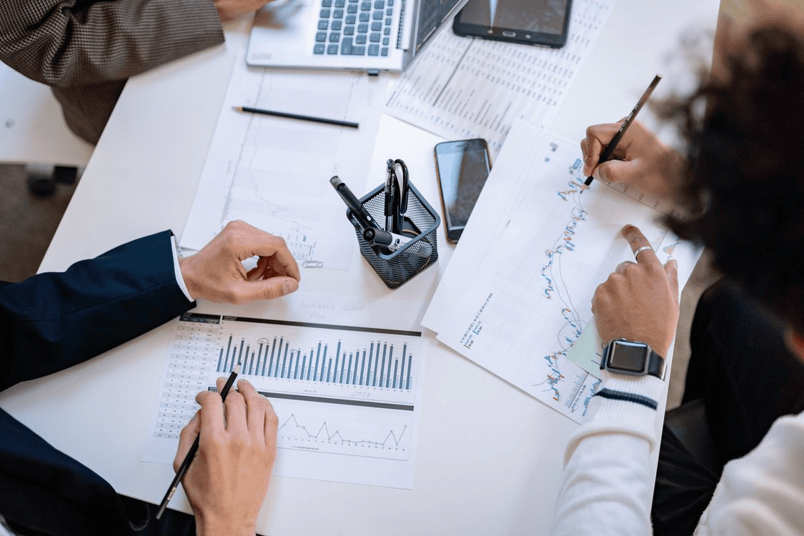 Business team analyzing financial charts and graphs during a collaborative meeting