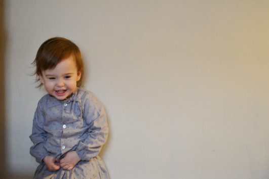 toddler in grey clothing smiling
