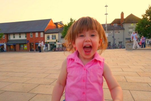 young child grinning outside