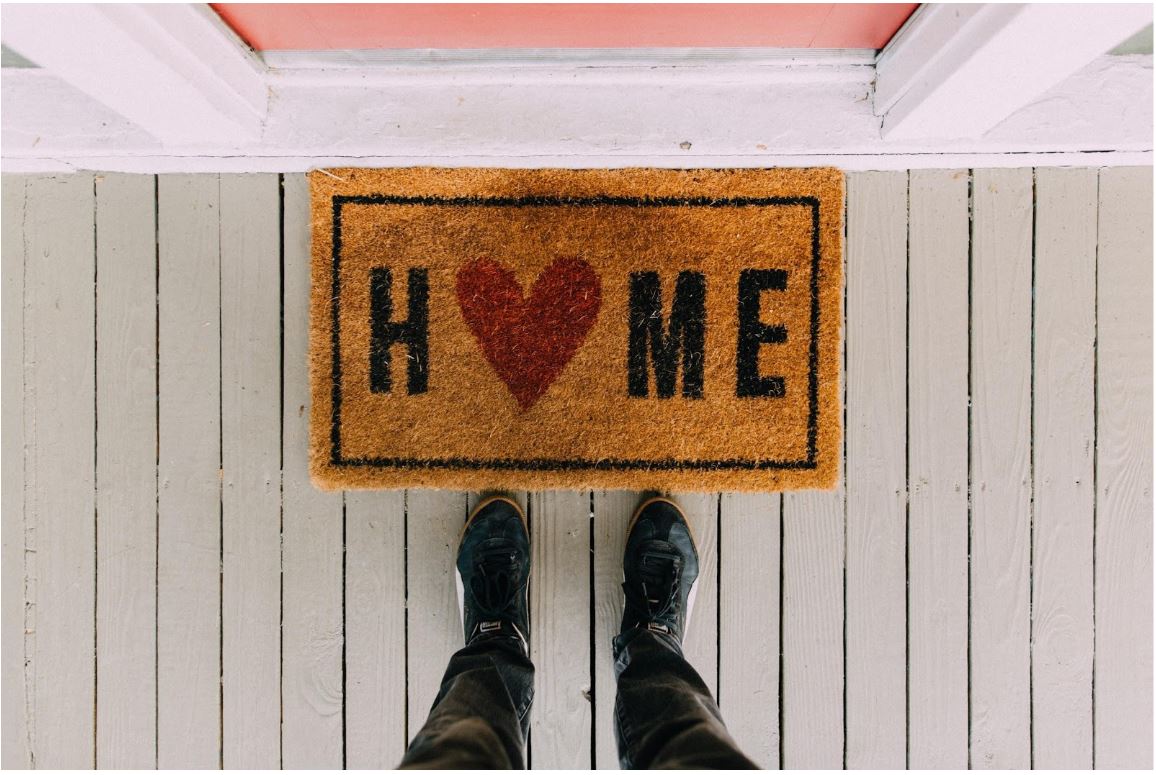 door mat with 'home' words on it with a red heart shape as the 'o'
