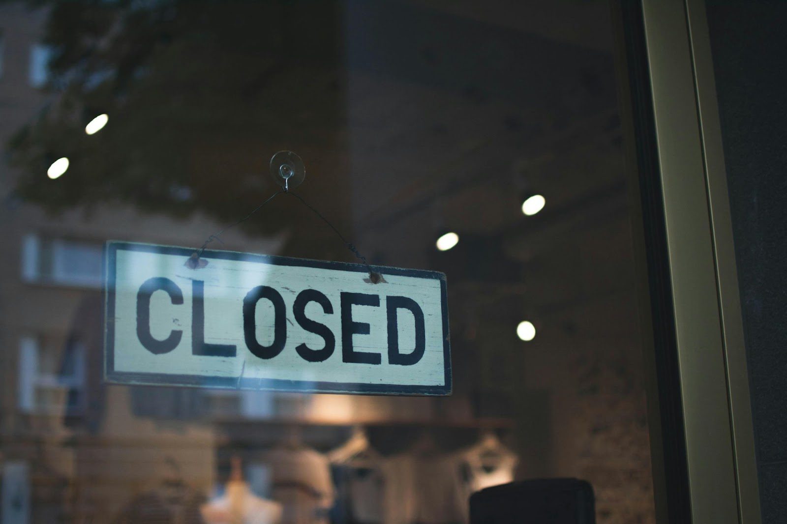 closed sign in shop window with reflections