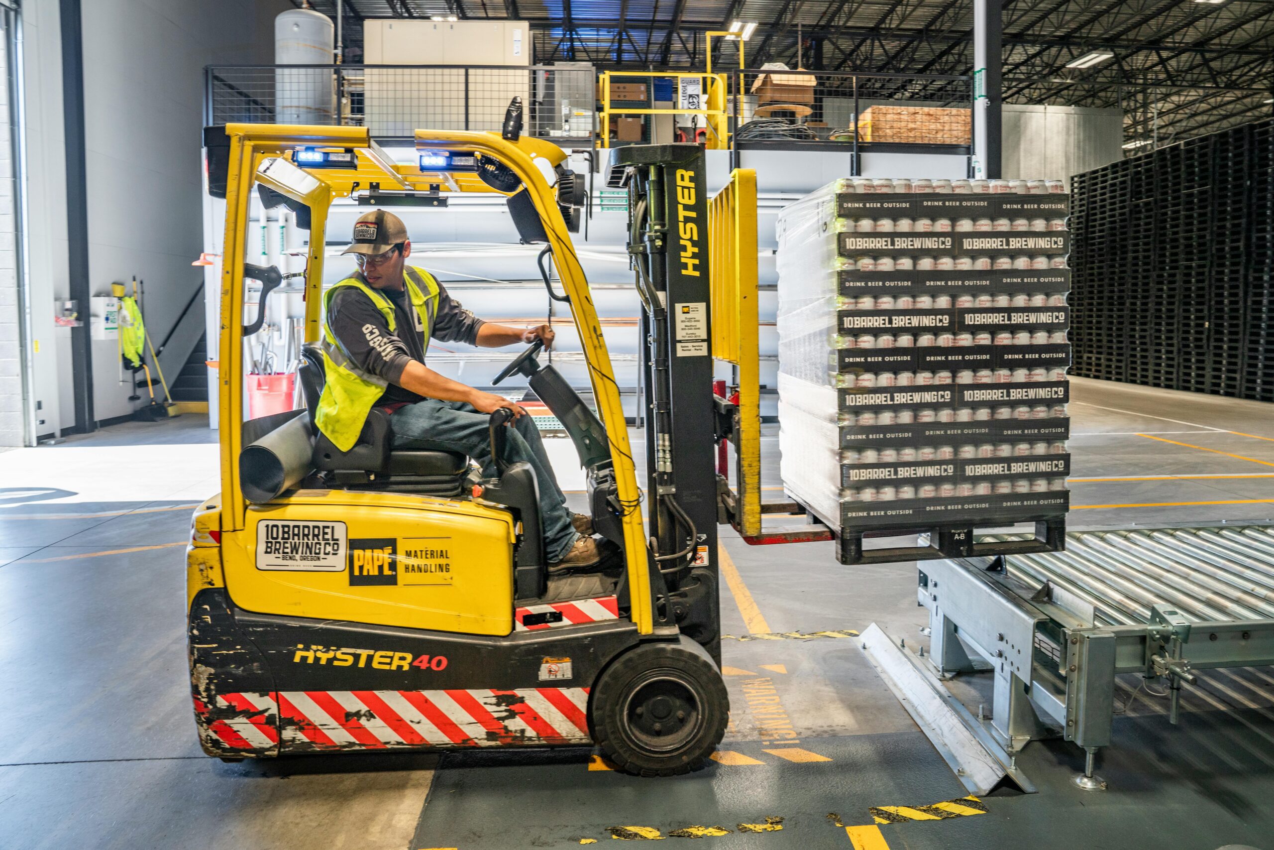 person driving yellow machinery in factory