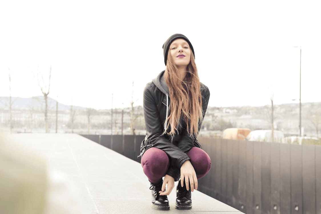 Selective Photo of Woman in Grey Hooded Jacket in a Crouched Position
