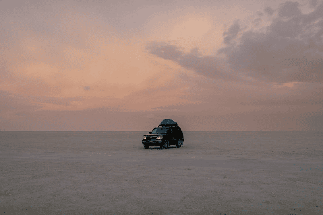 car with roof rack on in middle of dry desert