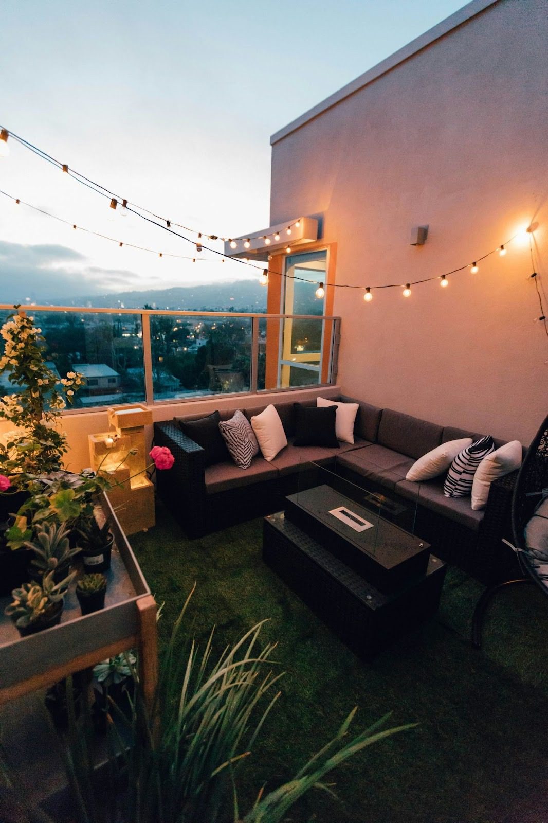outdoor balcony area with string lights, a sofs and lots of cushions
