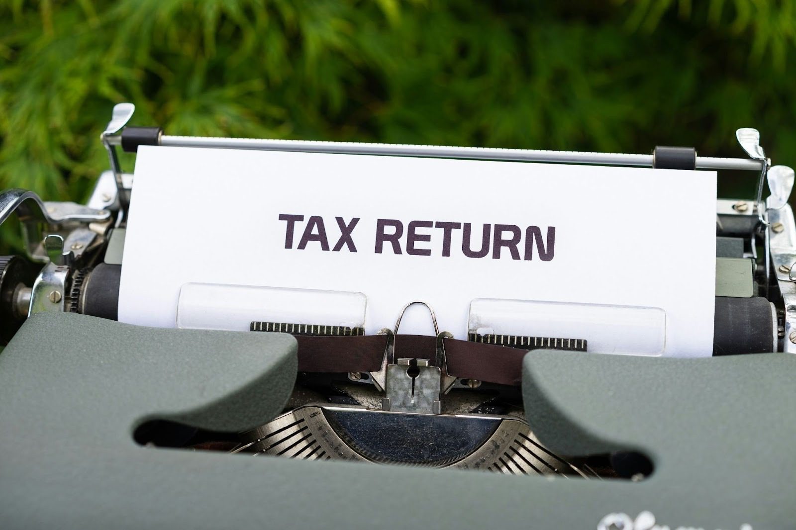paper coming out of typewriter saying the words 'tax return'