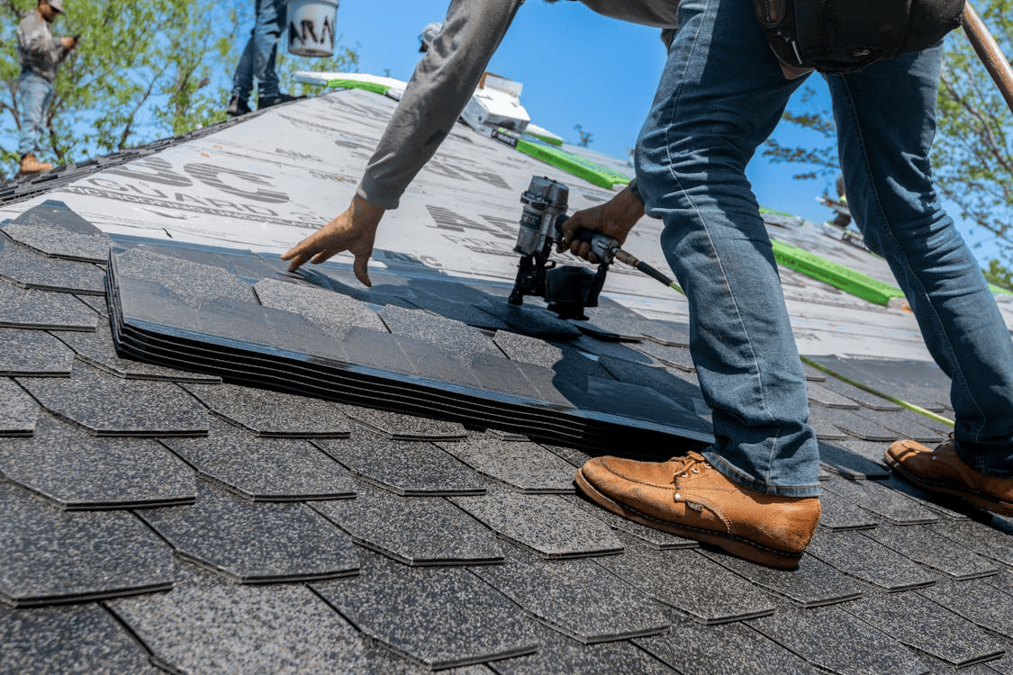 man on roof working on roof tiles
