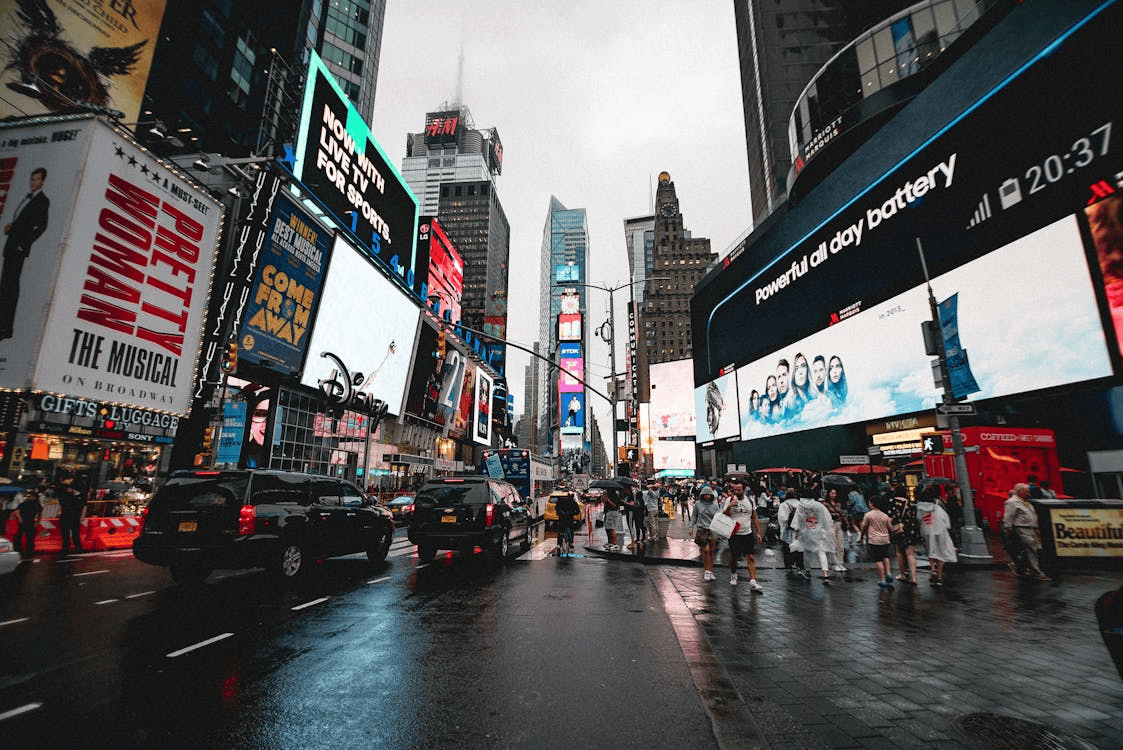 times square in new york with lit up billboards and lots of people