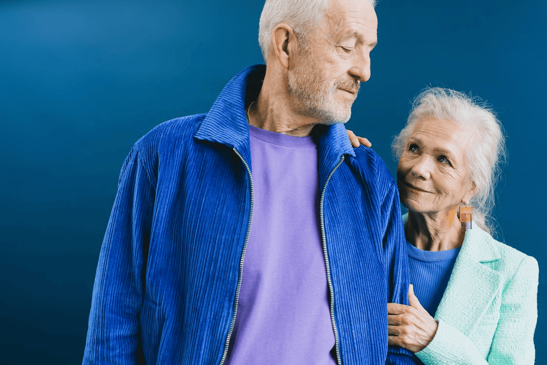 older couple holding onto each other and woman smiling