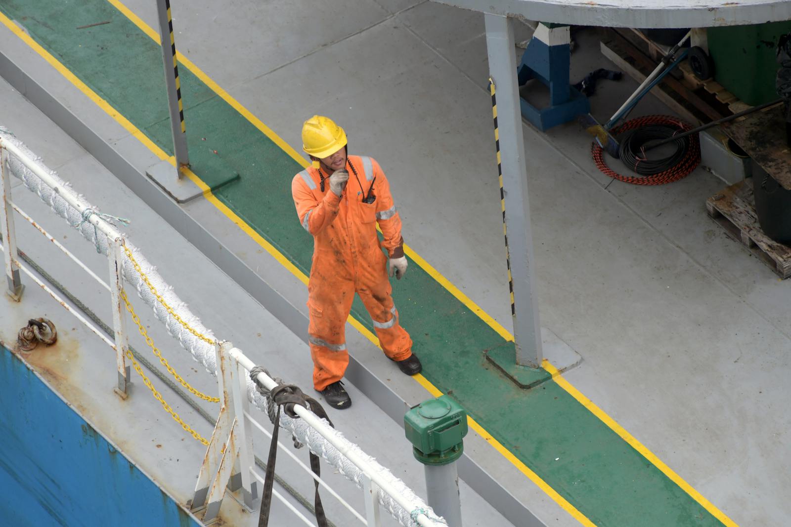 Overhead view of a worker in safety gear on a ship dek