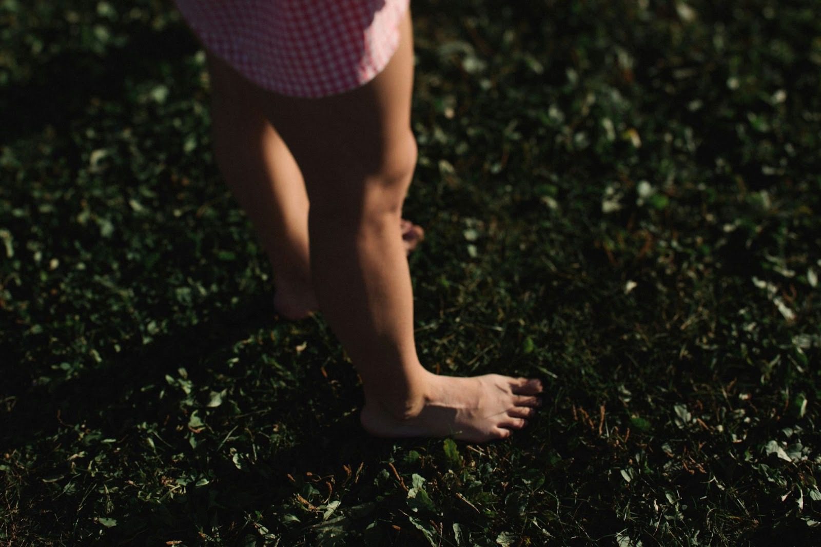 woman with bare legs and feet standing on grass