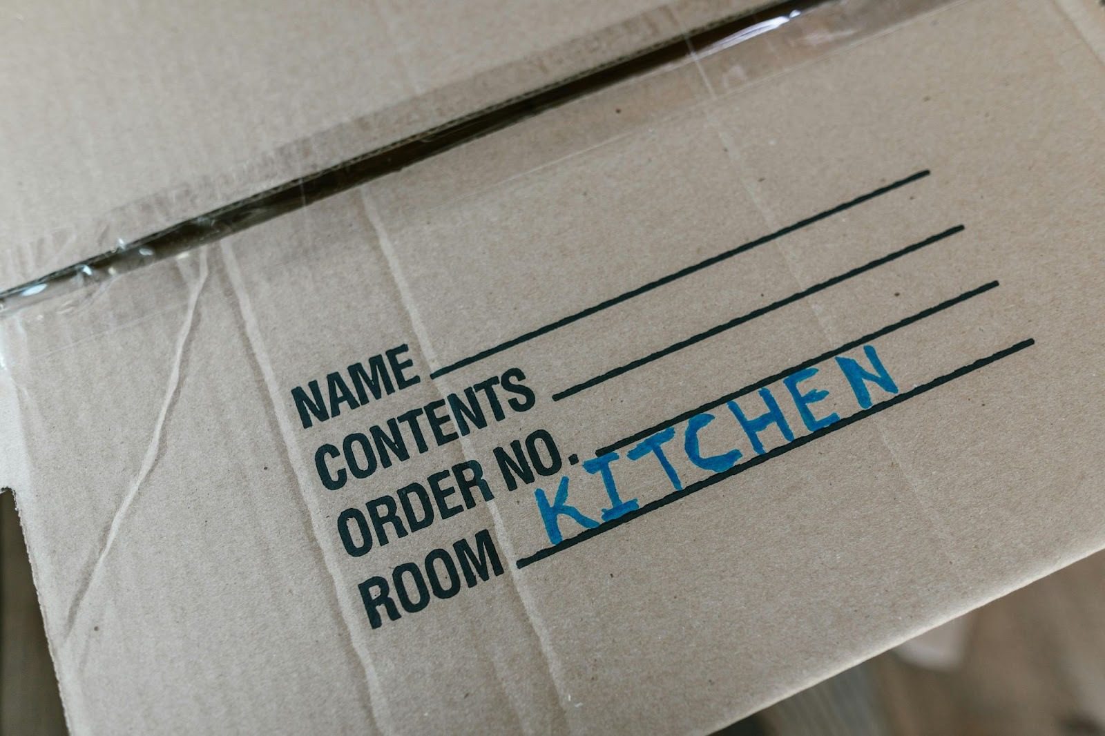 cardboard box with 'kitchen' written on it