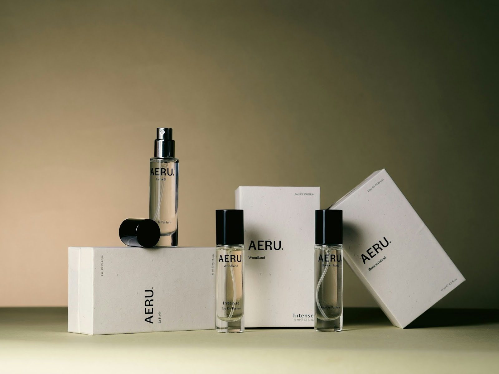 bottles of perfume leaning against white boxes with black writing