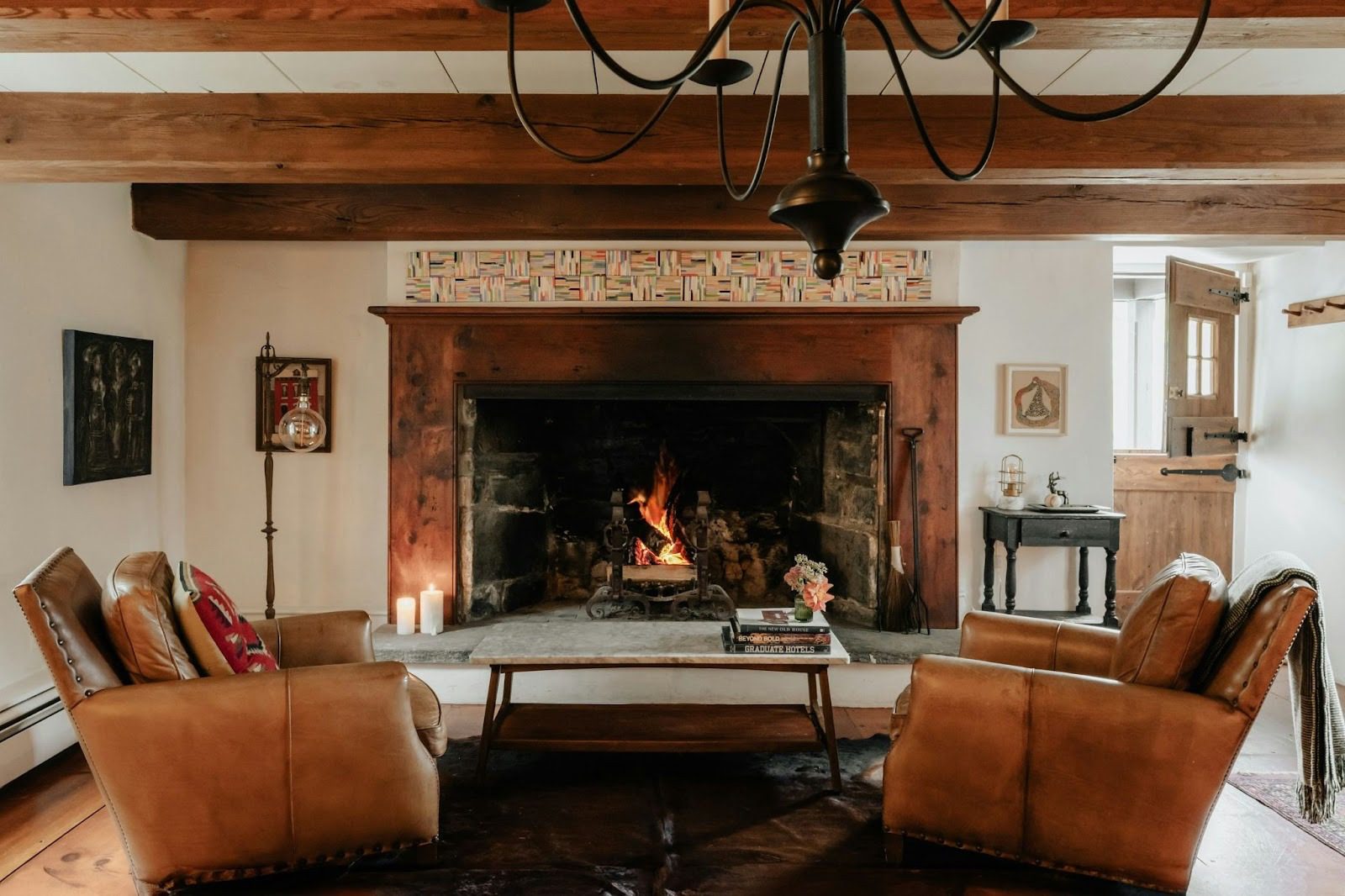 large cottage living room with open fire, stable door, coffee table and leather armchairs