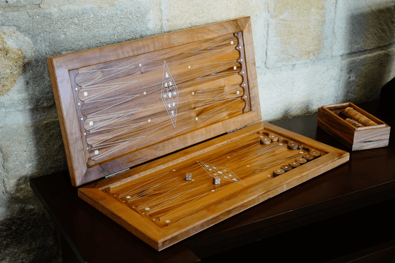 Open Wooden Backgammon Set on Table against brick wall