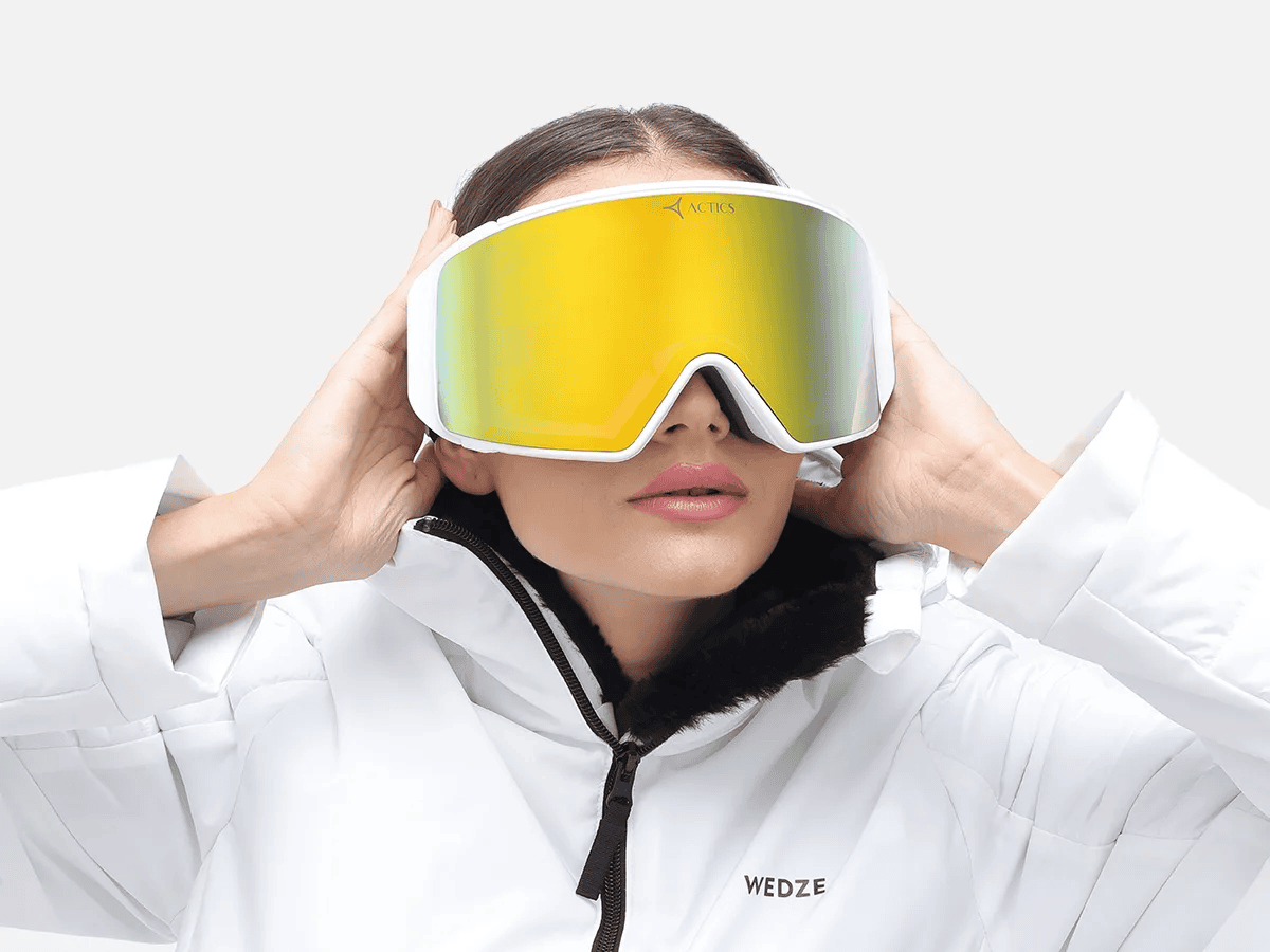 woman in ski goggles and white ski jacket