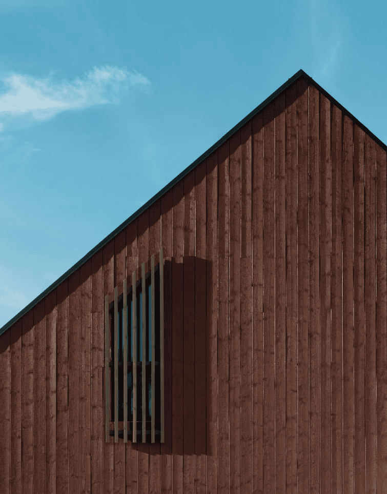 side of wooden house with blue sky behind