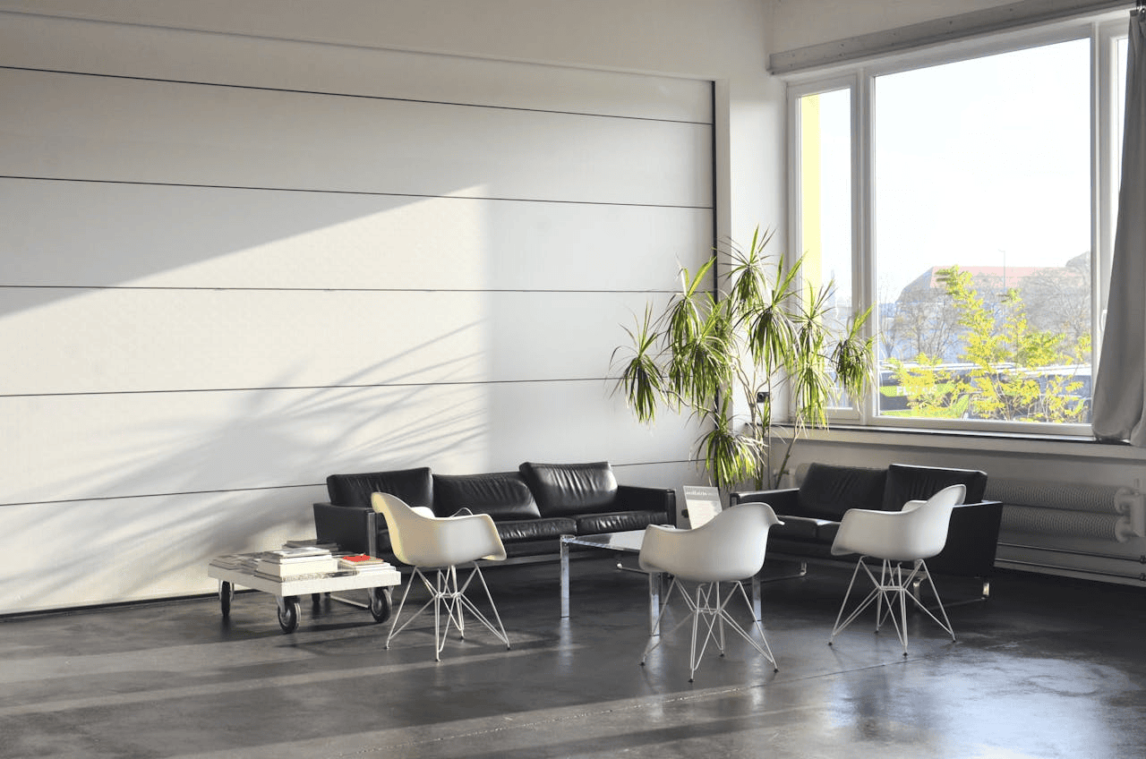 open space with brown leather sofas and white chairs