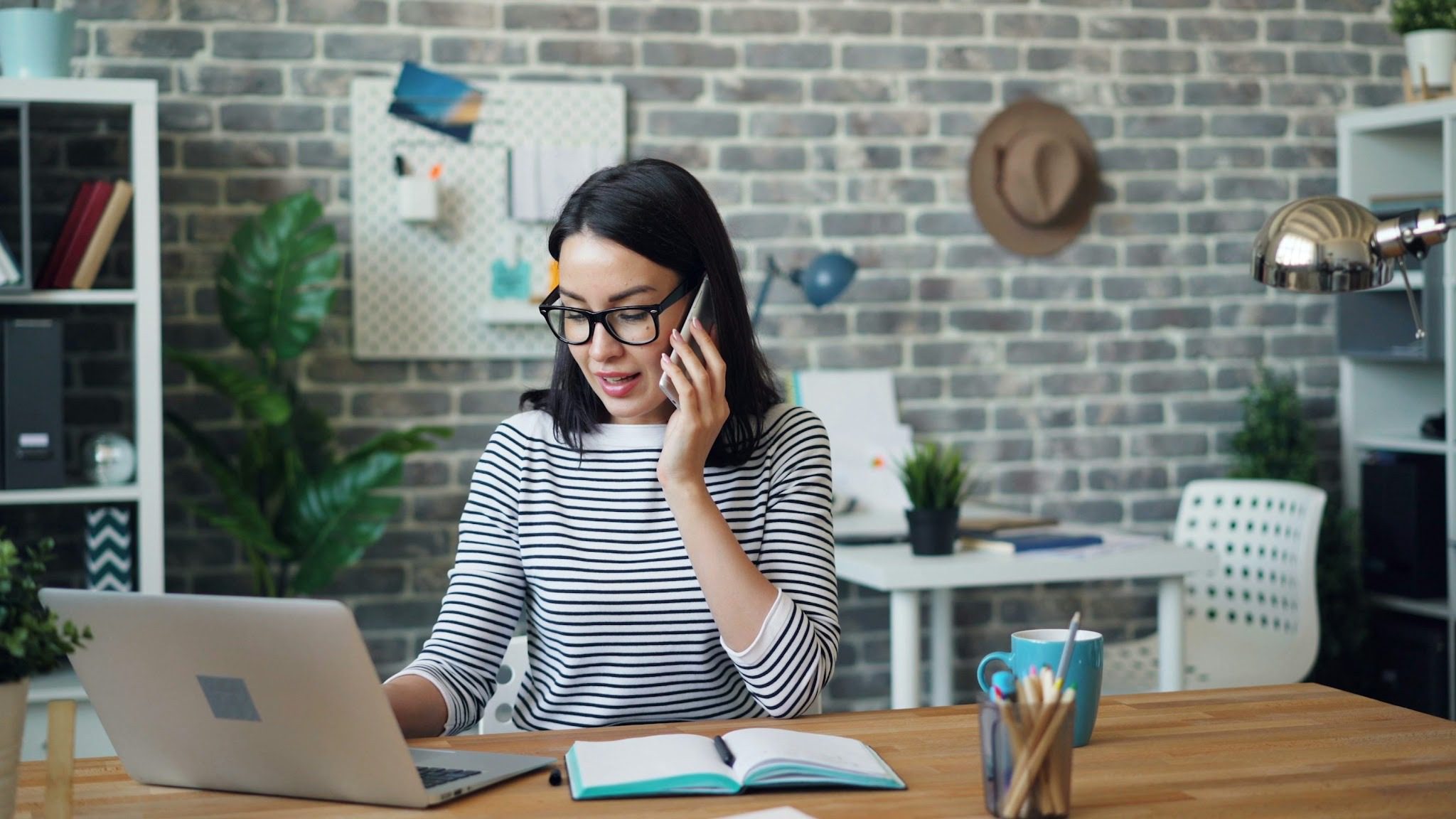 woman on phone sitting at desk