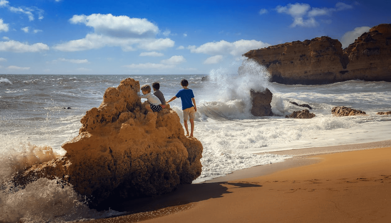 kids playing on rocks on a beach