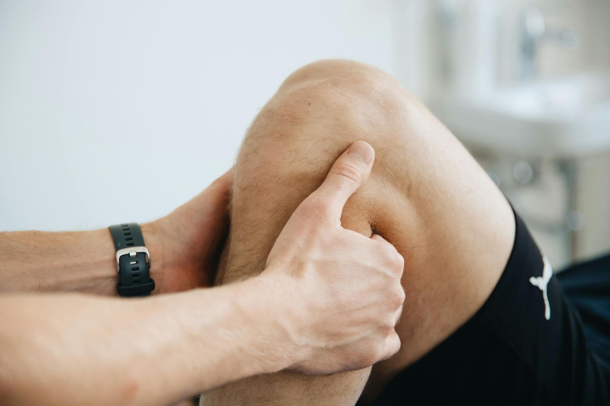 person holding onto man's leg for physio