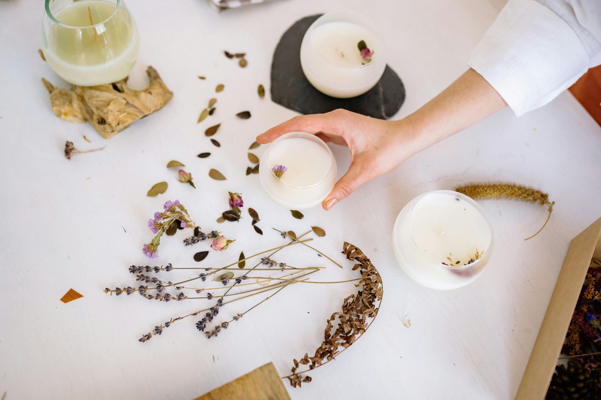 person' hand holding whit candle over table