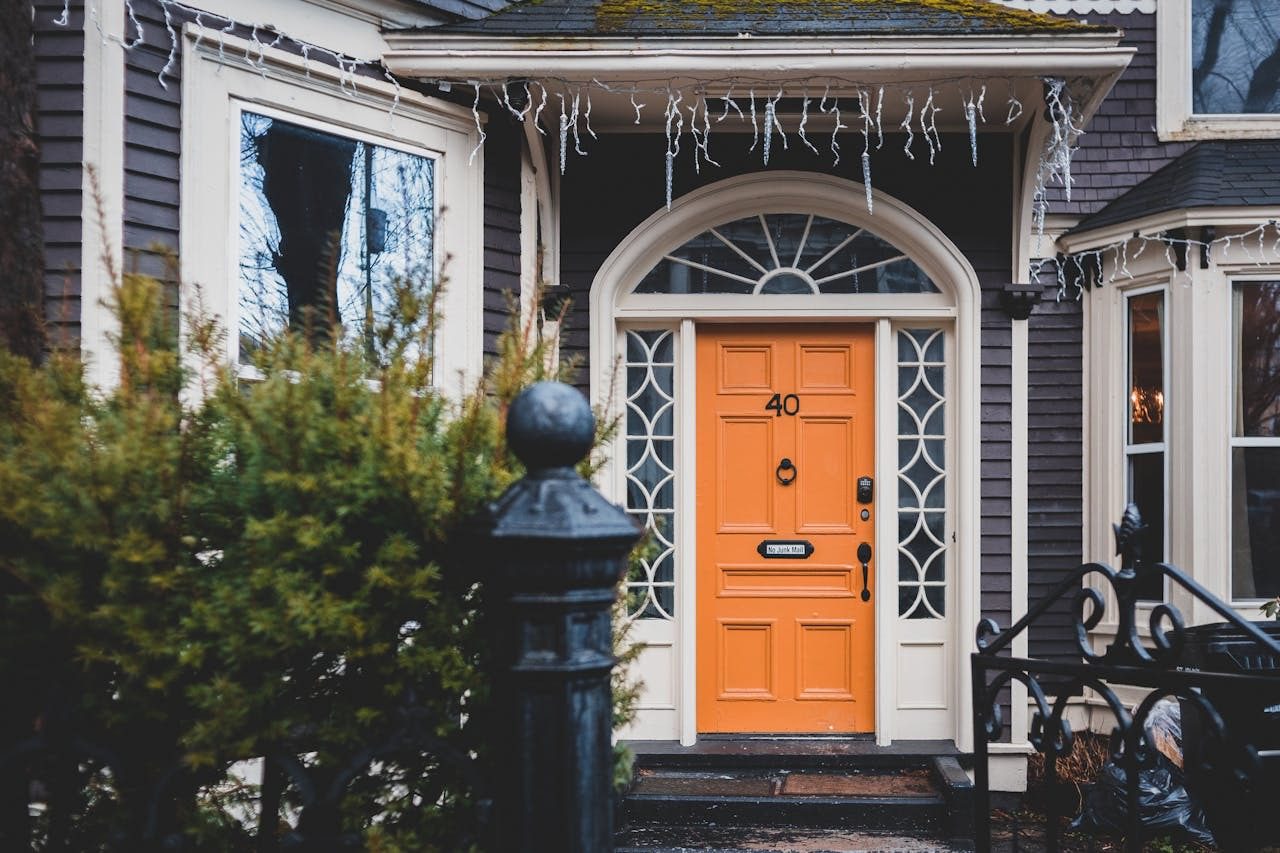 grey and white house with orange front door