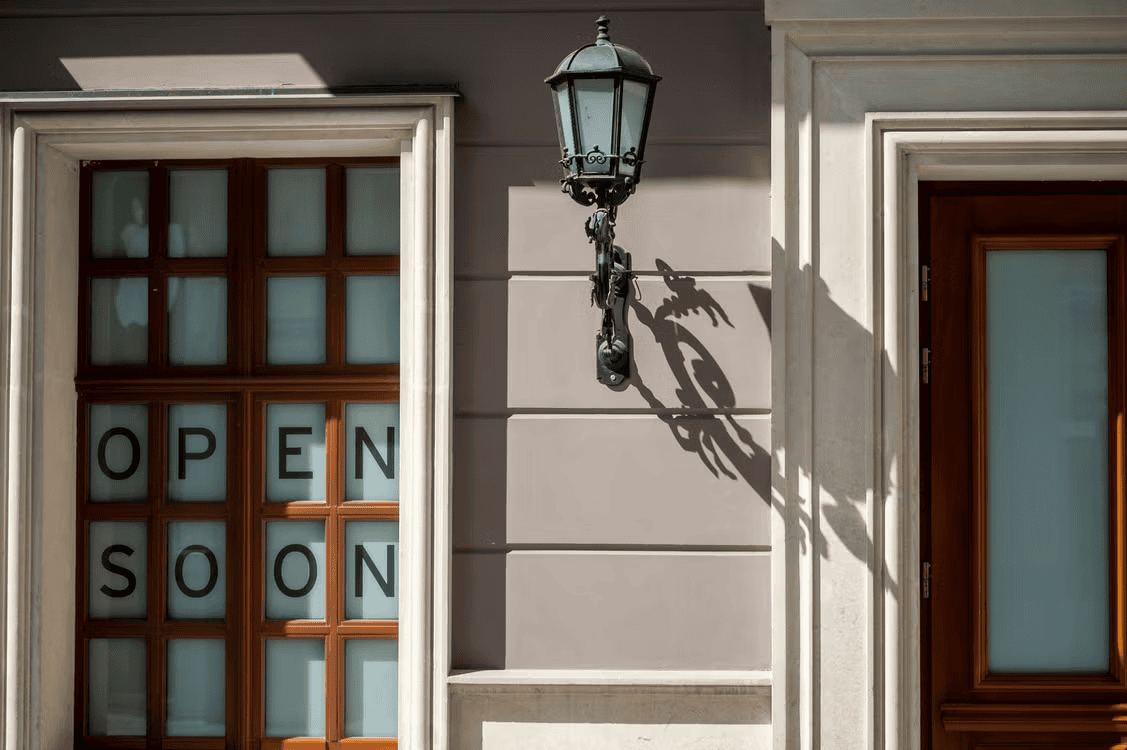 building with door saying 'open soon' on it
