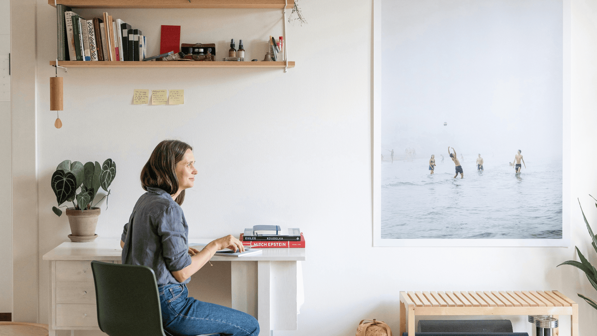 woman sitting sideways on chair at desk in home and smiling