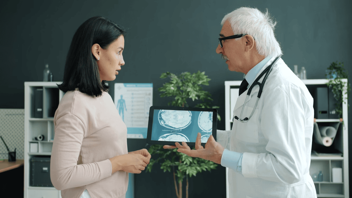 doctor standing in front of woman, showing her a screen