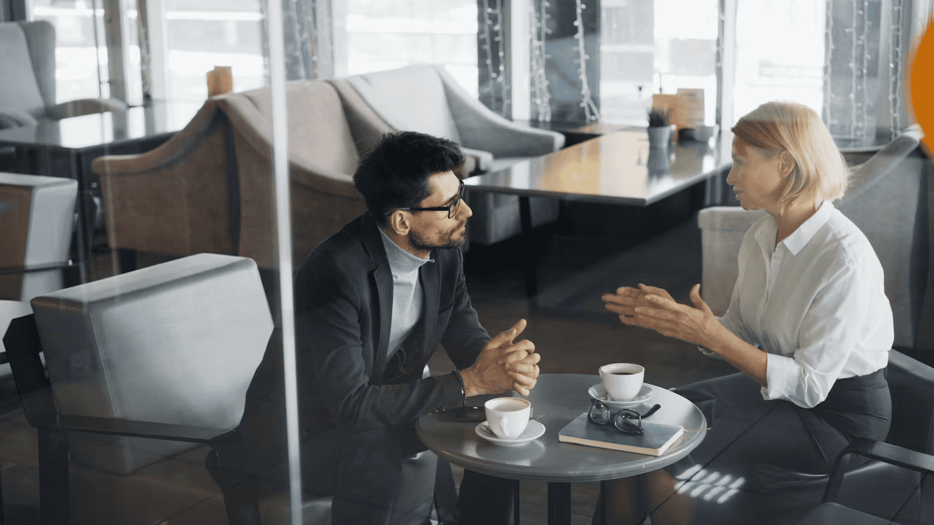 man and woman sitting at table in cafe and chatting